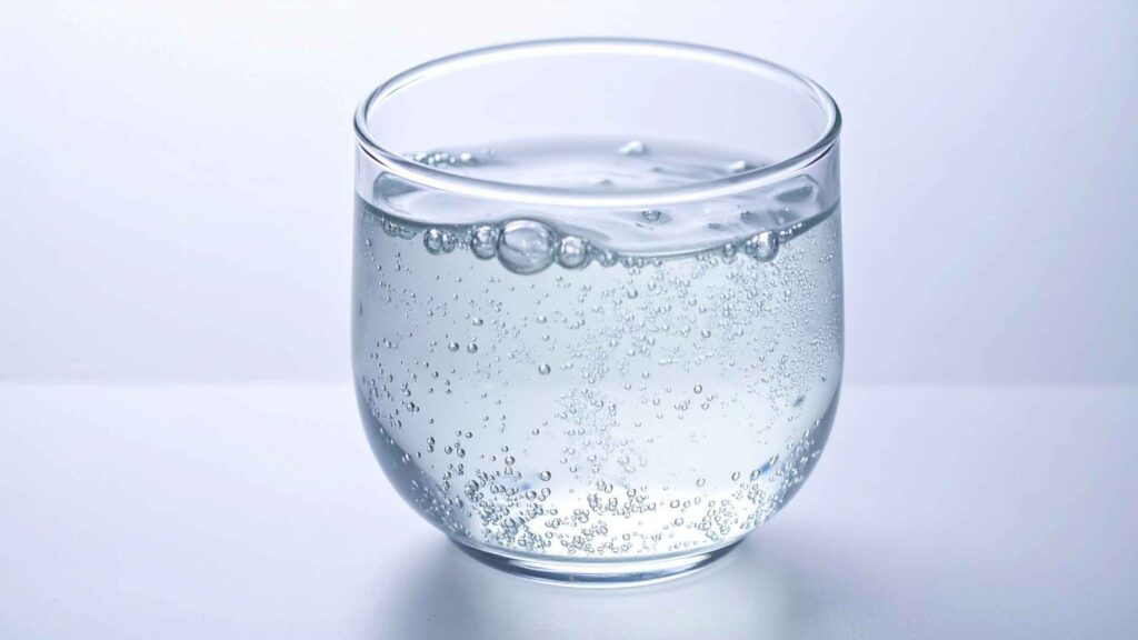 Glass of sparkling water illustrating its effects on tooth enamel